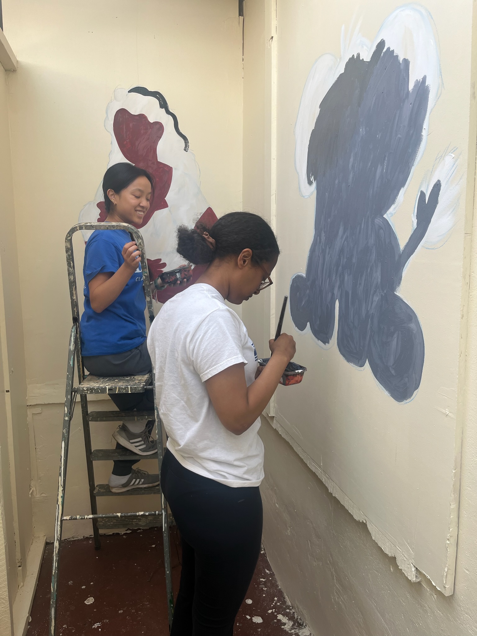 Students painting murals in hallway at Lumumba Hospital